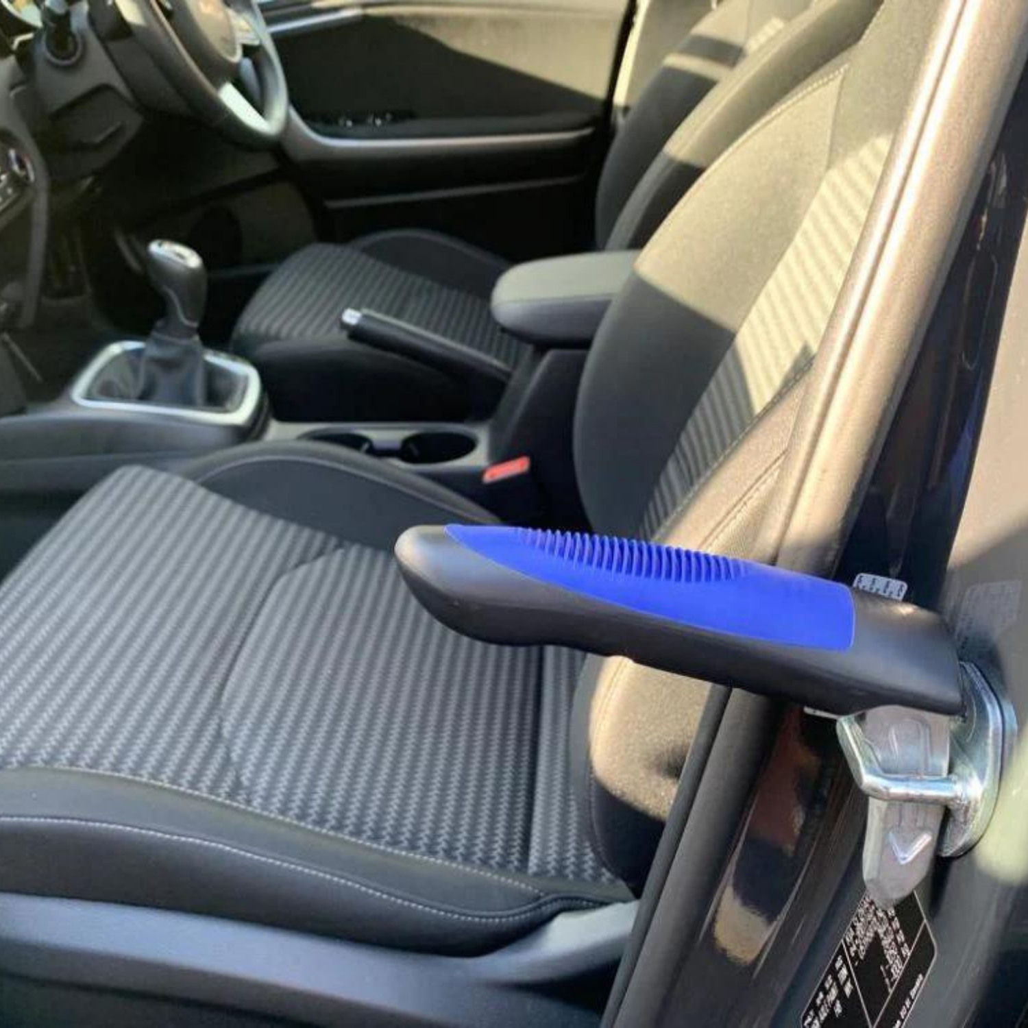 Car interior with a blue and black car assistance handle attached to the door